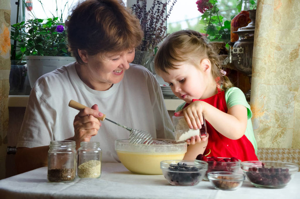 Портрет обличчя, руки щаслива бабуся, онука. маленька дівчинка грає з випічкою, тістом, борошном на кухні. дитяча дитина спробуйте вивчити кулінарне печиво, торт. Затишна сім'я Подивіться один на одного
 - Фото, зображення