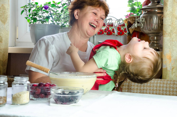 Πορτρέτο των προσώπων, τα χέρια ευτυχισμένο γιαγιά αγκάλιασμα εγγονή. νήπιο κορίτσι παίζουν με τη γιαγιά στην κουζίνα. παιδί μωρό κρατήσει τη γιαγιά και γέλιο. Άνετη οικογένεια Κοιτάξτε ο ένας τον άλλο - Φωτογραφία, εικόνα
