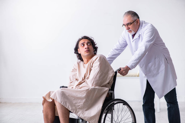 Γέρος άνδρας γιατρός ψυχίατρος και ασθενής σε αναπηρική καρέκλα   - Φωτογραφία, εικόνα