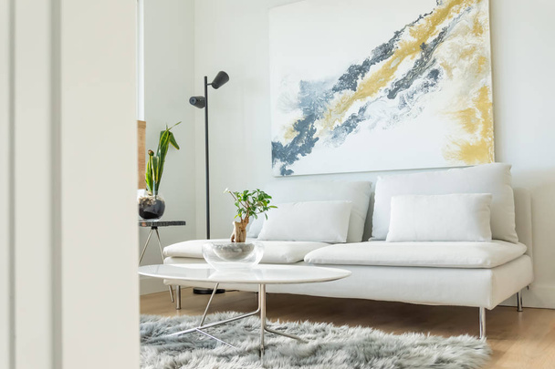 Apartman nappali szög megtekintéséhez, fehér bútorokkal és modern belsőépítészet, és néhány ház növények. Futon kanapé, dohányzóasztal, oldalsó asztal és falra művészet bemutató. - Fotó, kép