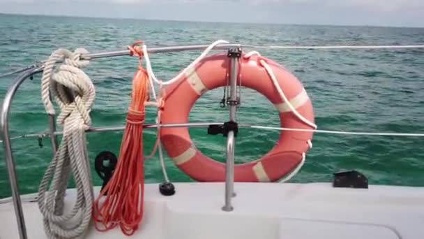 青い穏やかな海水の背景の上に赤い生命ブイ。ボートのライフブイ - 映像、動画