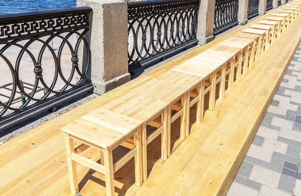 Drewniane stołki bez pleców stoją w rzędzie na nasypie - Zdjęcie, obraz