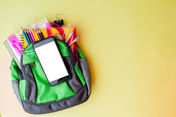 Flat lay composition with backpack and school stationery on yell - Foto, afbeelding