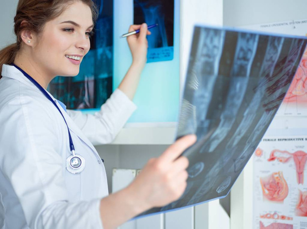 Young female doctor looking at the x-ray picture of lungs in hospital - Foto, immagini