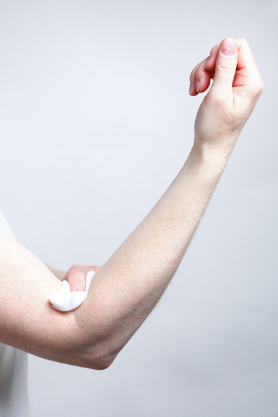 appying a swab to an arm after blood sample - Photo, image