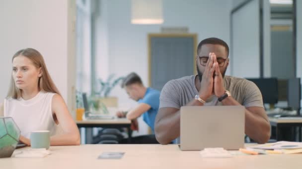 Zdenerwowany człowiek czyta złe wieści na komputerze przenośnym w Coworking Space - Materiał filmowy, wideo