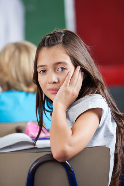 Schoolgirl Leaning On Chair In Classroom - Photo, image