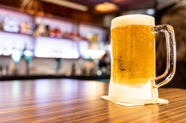 Korsó hideg, frissítő sör pub háttérrel - Fotó, kép