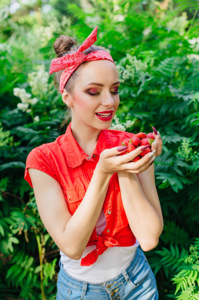Beautiful young pin up girl with bright make up and fresh natural strawberry. - Fotografie, Obrázek