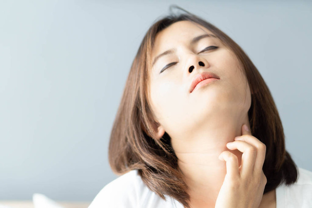 Close-up mulher segurando pescoço com dor depois de acordar na cama, cuidados saudáveis e conceito médico
 - Foto, Imagem