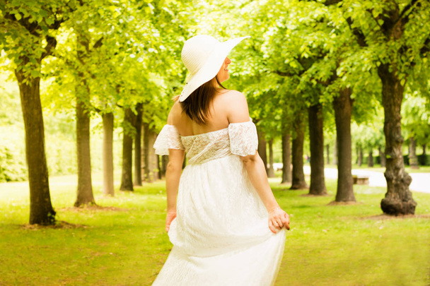 Gelukkige zwangere vrouw poseren over groene natuurlijke achtergrond - Foto, afbeelding