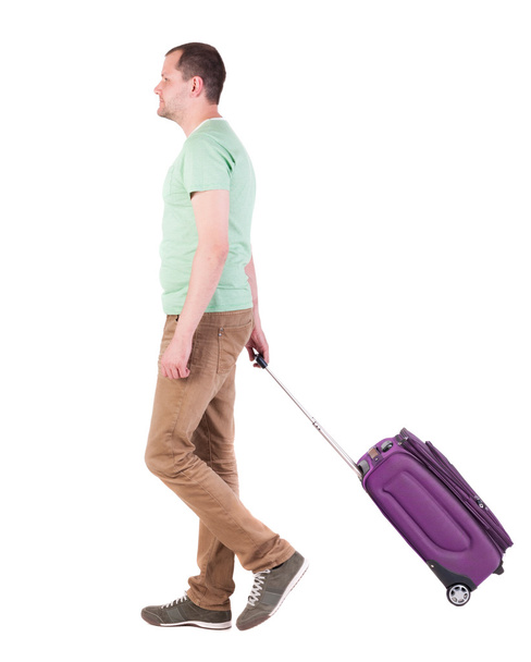 back view of walking man with suitcase. brunette guy in motio - Fotó, kép