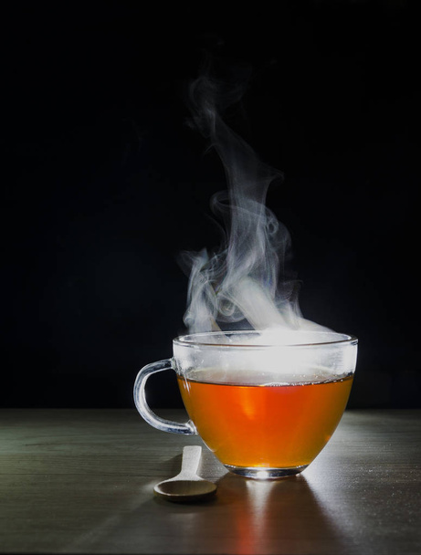 tasse en verre avec infusion de thé, sur fond noir avec étiquette pour écrire le texte
 - Photo, image