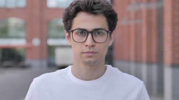 Portrait extérieur de jeune homme sérieux à lunettes
 - Séquence, vidéo