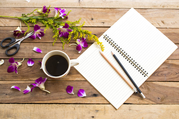 planificador de cuadernos para el trabajo de negocios con café espresso caliente, flores púrpura orquídea arreglo plano estilo laico sobre fondo de madera
 - Foto, Imagen