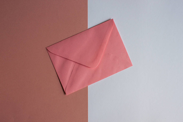 Enveloppe rose sur fond coloré
.  - Photo, image
