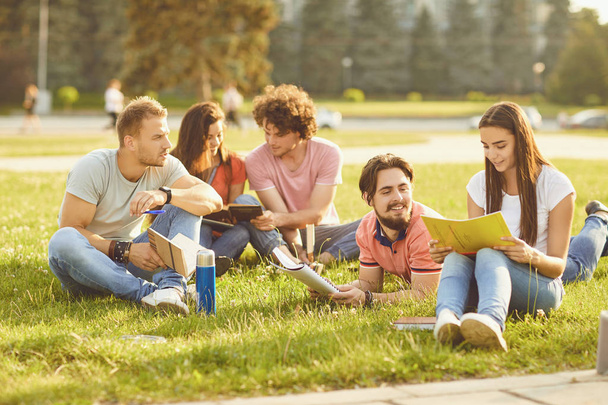 A group of students studying books sitting in a city park. - Φωτογραφία, εικόνα