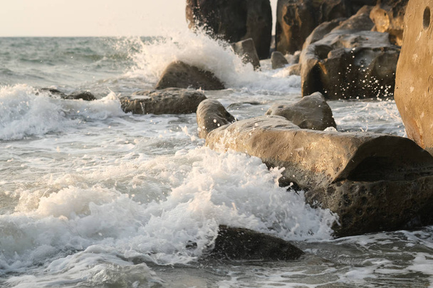 Meereswellen schlagen auf Felsen am Strand auf. - Foto, Bild