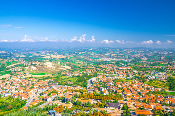 青い空の白い雲の背景と共和国サンマリノ郊外地区の谷、緑の丘、フィールドや村と風景の空中トップパノラマビュー。サンマリノ要塞からの眺め - 写真・画像
