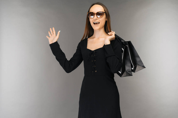 Black friday sale concept. shockedwoman holding bag isolated on background in holiday - Fotografie, Obrázek