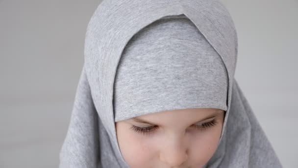 Joven musulmana adolescente chica en hijab tímidamente mirando a la cámara y sonriendo
. - Metraje, vídeo