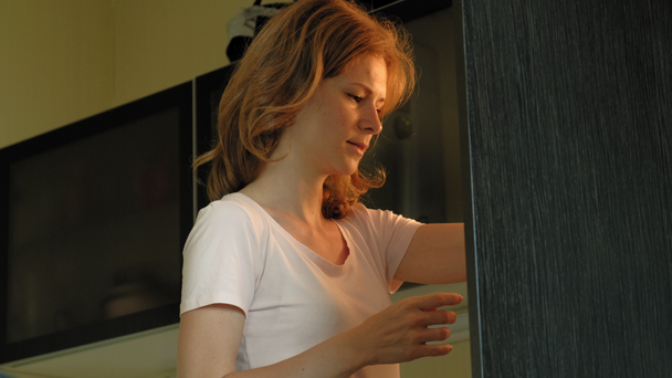 A young woman opens the refrigerator, chooses products. Morning - Video, Çekim