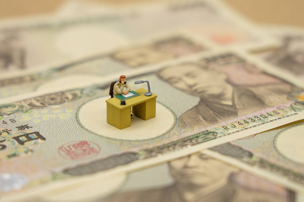 Miniaturní podnikatelé, kteří sedí s japonskými bankovkami - Fotografie, Obrázek