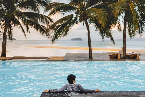 Asijští muži relaxaci v bazénu letní prázdniny na pláži - Fotografie, Obrázek