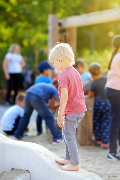 Little boy having fun on outdoor playground of public park at sunny summer day. - Fotoğraf, Görsel