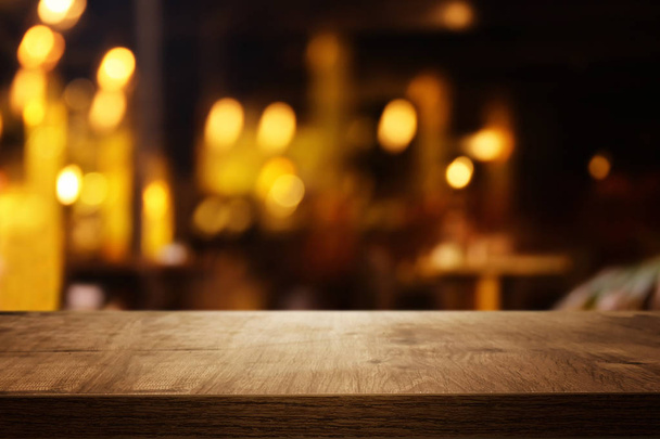 háttérben a fából készült asztal előtt absztrakt homályos étterem fények - Fotó, kép