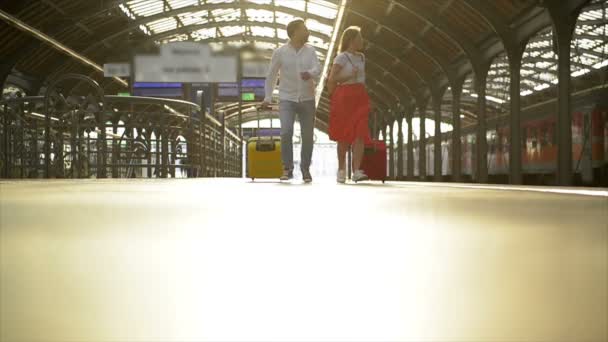 Running Couple With A Suitcase In A Train Station. Woman Holding Passports In Her Hands While Train Is Departed. - Materiaali, video