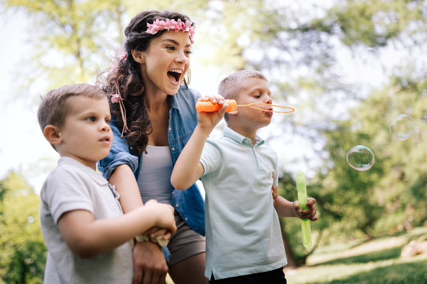 Happy family with children blow soap bubbles outdoor - Foto, imagen
