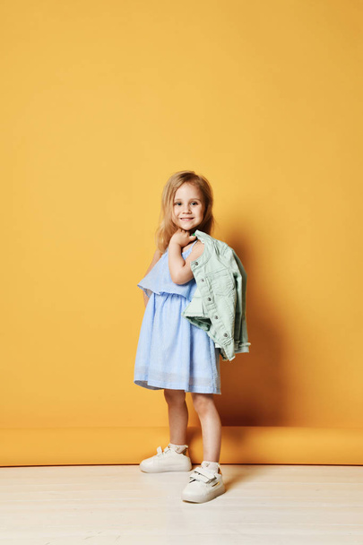Full length portrait of a cute little child girl in a stylish dress and denim. - Foto, immagini