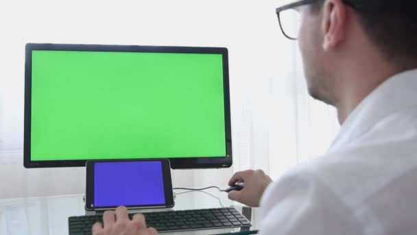Inżynier, Konstruktor, Projektant w okulary praca na komputerze osobistym z zielonym ekranie na monitorze, który ma Chroma Key Great dla szablonu makieta. - Materiał filmowy, wideo