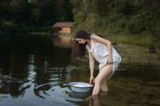 Jeune blanchisseuse debout dans la rivière
. - Photo, image