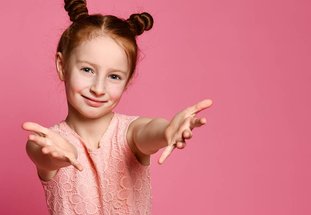 Studio shot of a friendly cute redhead little girl pulling hands towards - Photo, Image