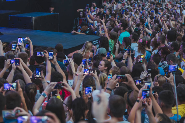 LVIV, UKRAINE - June 18, 2019: rock band singer on stage with microphone crowd around stage shooting on phones - Φωτογραφία, εικόνα