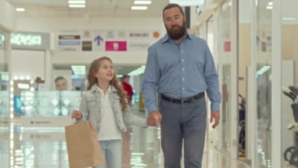 Liefdevolle vader wandelen in winkelcentrum met zijn schattige kleine dochter - Video