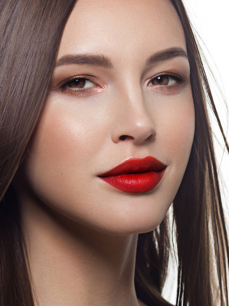 Close-up portrait of sexy european young woman model with classic glamour make-up and red lipstick. Dark long hairstyle, christmas makeup, dark eyeshadows, bloody red lips with gloss - 写真・画像