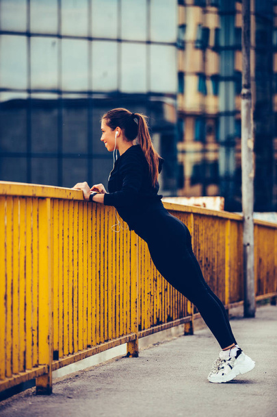 Sporty woman doing stretching exercises on the bridge and prepar - Фото, зображення