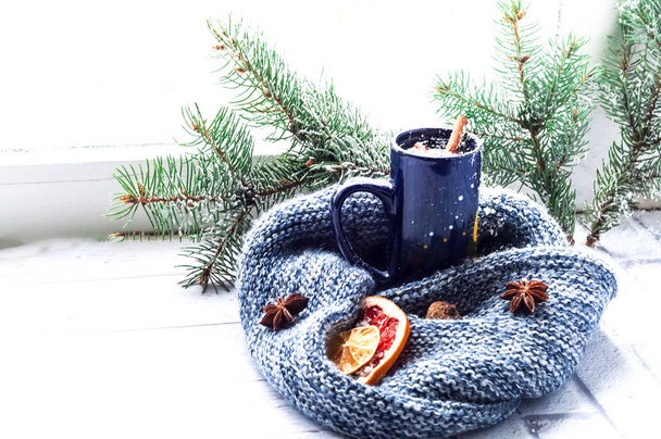 Taza azul con té y libro abierto en el fondo de la ventana con patrón de invierno
.  - Foto, imagen