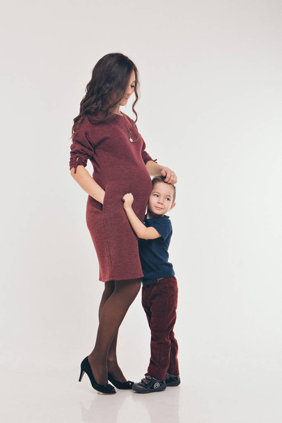 Happy kid girl hugging pregnant mother's belly, pregnancy and new life concept - Foto, Imagen