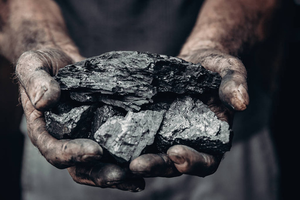 Mijnwerker houdt kolen, Palm textuur. Concept Mining, zwarte steen. - Foto, afbeelding