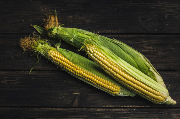 Corn on a dark wood background - Φωτογραφία, εικόνα