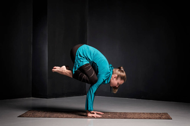 Woman practicing yoga, doing Crane exercise, Bakasana pose, working out. - Фото, зображення