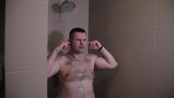 Cheerful funny man washes in the shower. - Πλάνα, βίντεο