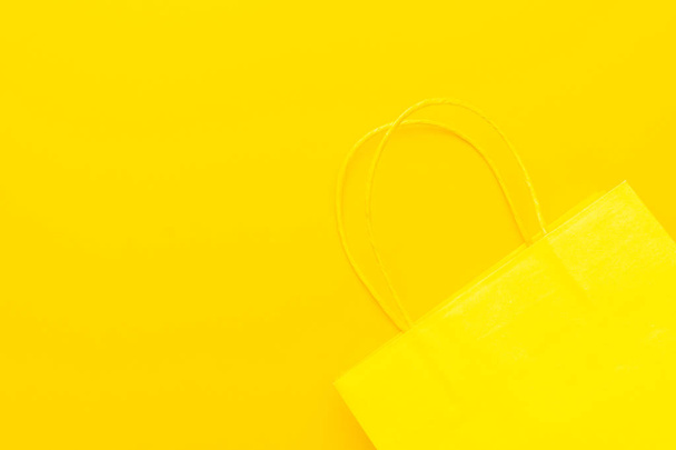 shopping paper bag on the yellow background with copy space. summer sale concept - Фото, изображение