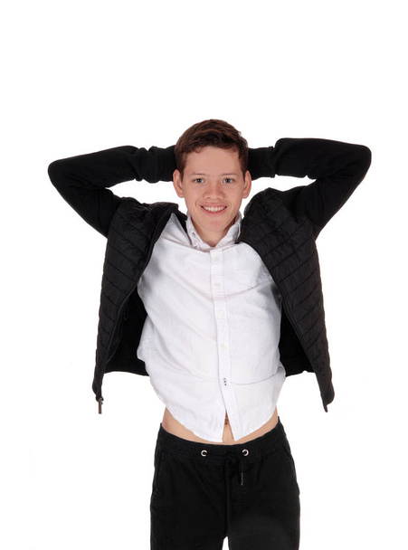 Gelukkige tiener jongen staande in een zwarte jas - Foto, afbeelding