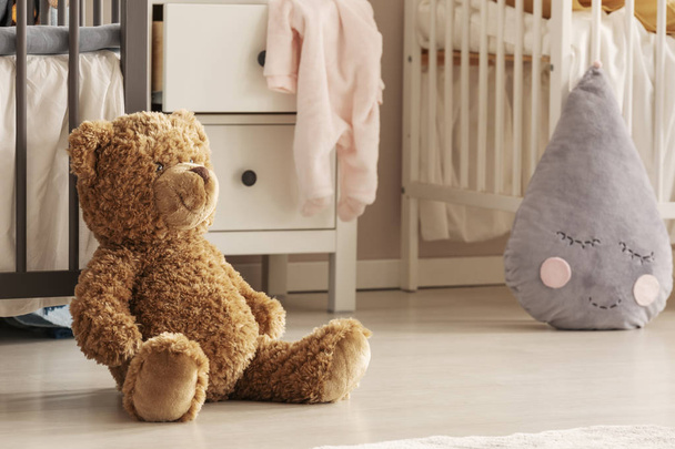 Closeup of teddy bear sitting on the floor of chic baby bedroom for twins - Fotoğraf, Görsel