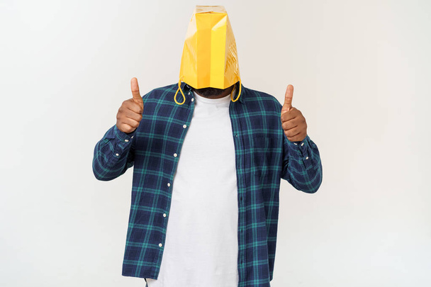 Man in paper bag on head showing with forefingers isolated on white background - Valokuva, kuva